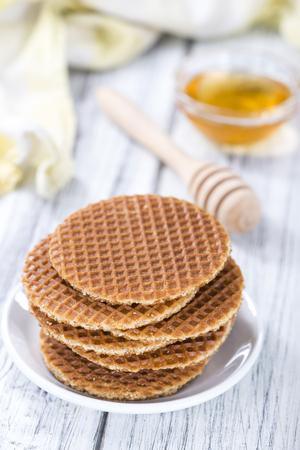 Crunchy homemade Waffles filled with golden honey on wooden backgroundの写真素材