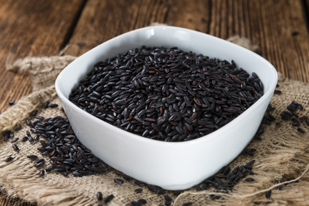 Uncooked Black Rice (detailed close-up shot) on wooden backgroundの写真素材