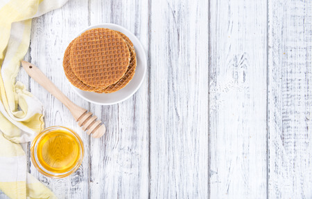 Crunchy homemade Waffles filled with golden honey (on wooden background)の写真素材