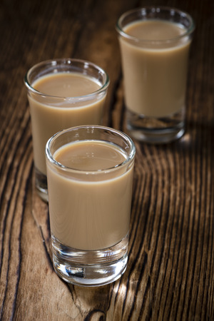 Glass with cold Cream Liqueur on vintage wooden backgroundの写真素材