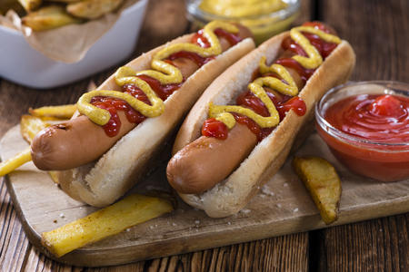 Hot Dog with ketchup and mustard (close-up shot) on wooden backgroundの写真素材