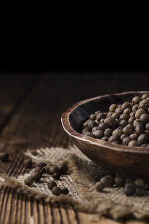 Portion of Allspice (detailed close-up shot) on wooden backgroundの写真素材