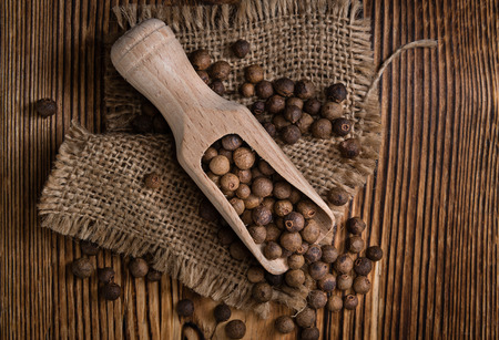Heap of dried Allspice (selective focus) on an old wooden tableの写真素材