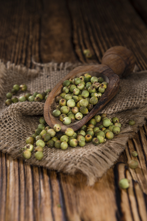 Whole green Peppercorns (close-up shot) on wooden backgroundの写真素材