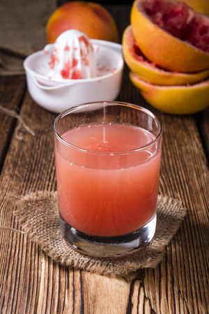 Pure Grapefruit Juice (close-up shot) on rustic wooden backgroundの写真素材
