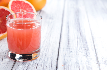 Pure Grapefruit Juice (close-up shot) on rustic wooden backgroundの写真素材