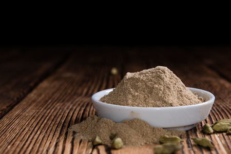 Heap of Cardamon Powder (close-up shot) on rustic wooden backgroundの写真素材