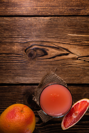 Freshly Squeezed Grapefruit Juice (close-up shot) on vintage wooden backgroundの写真素材