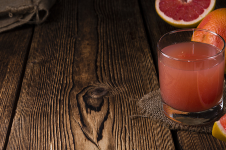 Pure Grapefruit Juice (close-up shot) on rustic wooden backgroundの写真素材