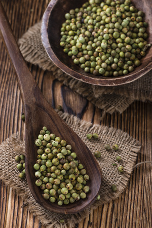 Peppercorns (green) as detailed close-up shot on vintage wooden backgroundの写真素材