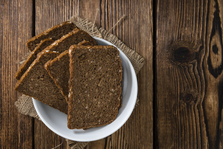 Brown Bread (sliced) on an old wooden table (selective focus)の写真素材