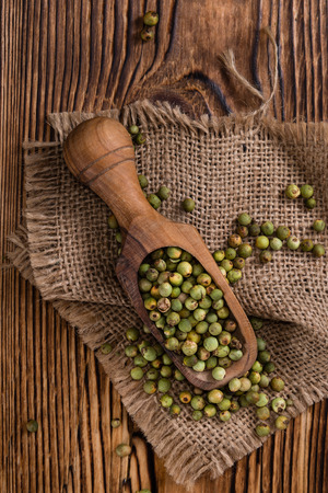 Peppercorns (green) as detailed close-up shot on vintage wooden backgroundの写真素材
