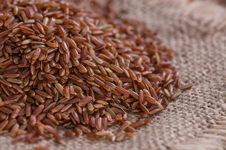 Heap of red Rice (close-up shot) on vintage wooden backgroundの写真素材