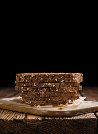 Slices of  Brown Bread (selective focus) on an old wooden tableの写真素材