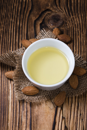 Bowl with almond oil (selective focus) on vintage wooden backgroundの写真素材