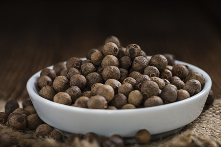 Portion of Allspice (detailed close-up shot) on wooden backgroundの写真素材
