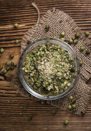 Crushed green Peppercorns (close-up shot) on vintage wooden backgroundの写真素材