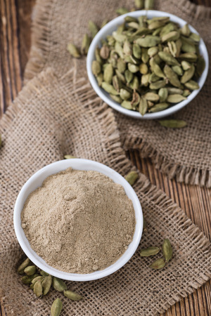Heap of Cardamon Powder (close-up shot) on rustic wooden backgroundの写真素材