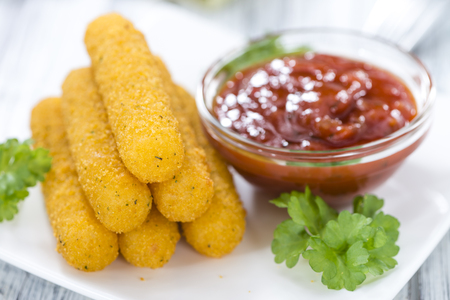 Portion of Mozzarella Sticks on an old wooden table (selective focus)の写真素材