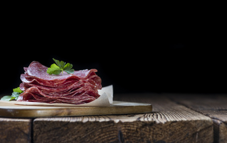 Slices Salami (selective focus) on an old vintage wooden tableの写真素材