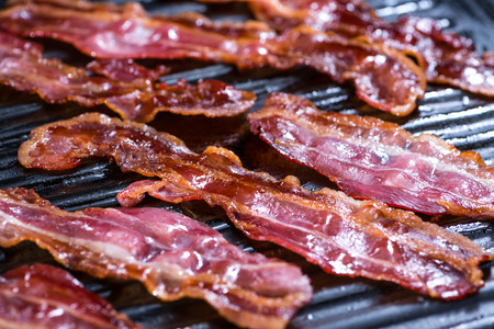 Skillet with fried Bacon (close-up shot and selective focus)