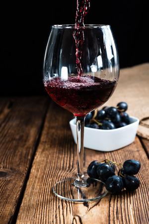 Old vintage wooden table with Red Wine (selective focus)の写真素材