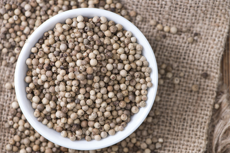 Some white Peppercorns (close-up shot) on wooden backgroundの写真素材