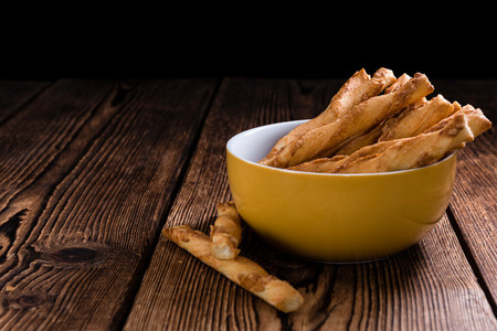 Crispy Pastry Sticks on wooden background (close up shot, selective focus)