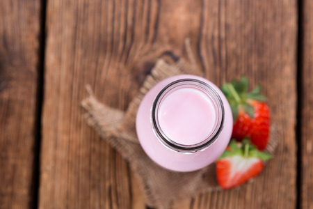 Milk (Strawberry flavoured) on wooden background (selective focus)の写真素材