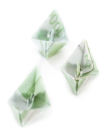 Boats made out of European banknotes on white background (close-up shot)の写真素材