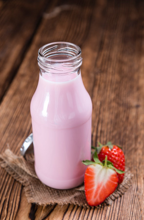 Milk (Strawberry flavoured) on wooden background (selective focus)の写真素材