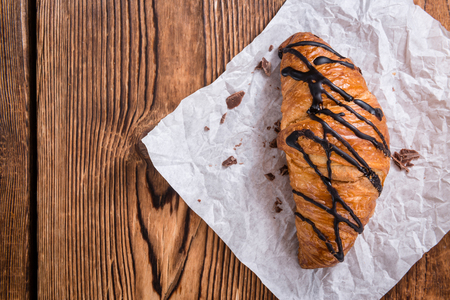 Fresh made Chocolate Croissants (selective focus) on wooden backgroundの写真素材
