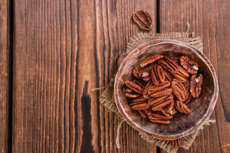 Heap of Pecan Nuts (selective focus) on an old wooden tableの写真素材