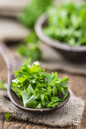 Some fresh Parsley (close-up shot; selective focus) on an old wooden tableの写真素材