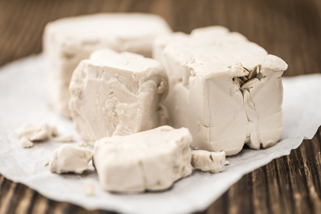 Heap of Yeast (selectivce focus) on wooden background (close-up shot)の写真素材