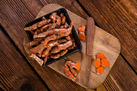 An old wooden table with Turmeric (selective focus, close-up shot)の写真素材