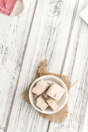 Portion of fresh Yeast (selective focus) on wooden backgroundの写真素材