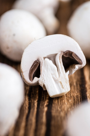 White Mushrooms (selective focus) on an old wooden tableの写真素材