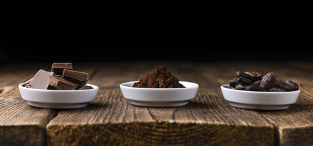 Milk Chocolate (selective focus) on wooden background (close-up shot)