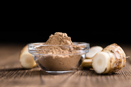 Portion of Galangal Powder(detailed close-up shot; selective focus) on wooden backgroundの写真素材