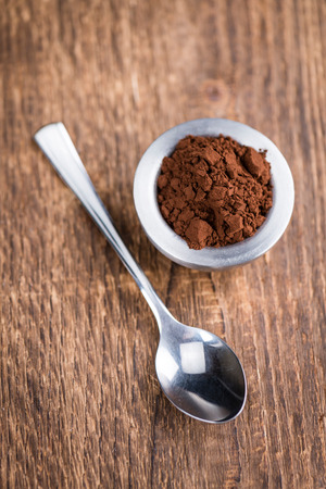 Portion of natural Cocoa powder on an old wooden table (selective focus)の写真素材