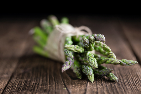 Green Asparagus (fresh harvested) on an old wooden table (selective focus)の写真素材