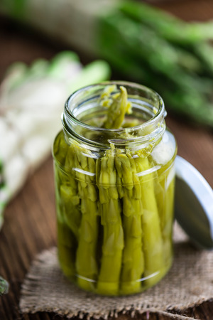 Portion of green Asparagus (preserved) on a wooden tableの写真素材