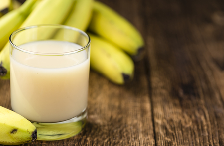 Banana juice (selective focus) on an old wooden table (detailed close-up shot)の写真素材