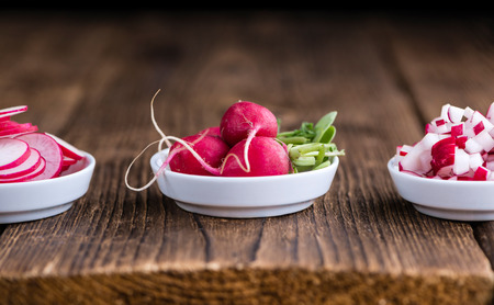Radishes (whole, sliced and diced) as detailed close-up shot (selective focus)
