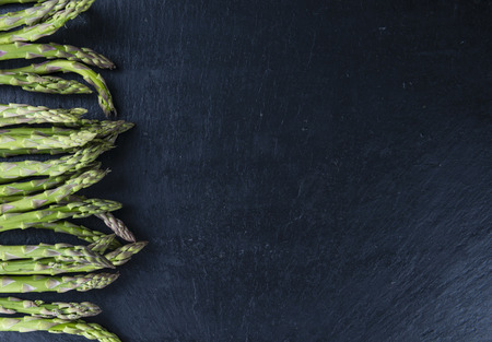Green Asparagus (close-up shot) on a slate slab (selective focus)の写真素材