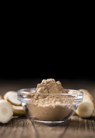 Galangal Powder(detailed close-up shot) on an old wooden tableの写真素材