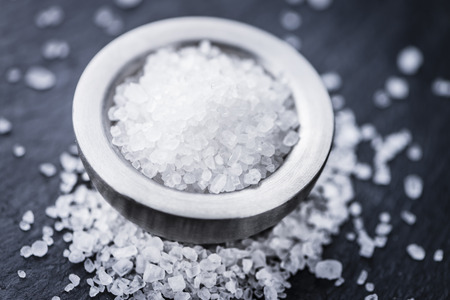 Heap of Coarse Salt (close-up shot) on vintage background (selective focus)