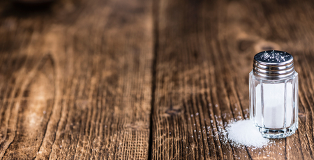 Old wooden table with a Salt Shaker (close-up shot; selective focus)の写真素材
