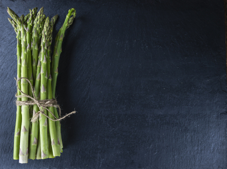 Green Asparagus (close-up shot) on a slate slab (selective focus)の写真素材